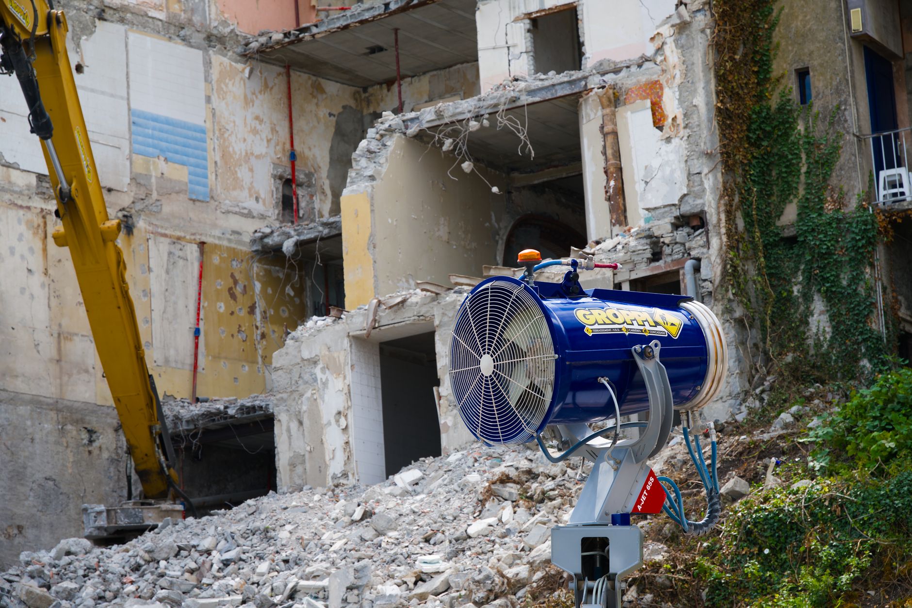 Industrial demolition with dust control machine and debris. Outdoors in daylight